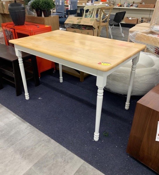 Wood-top farmhouse dining table on the showroom floor